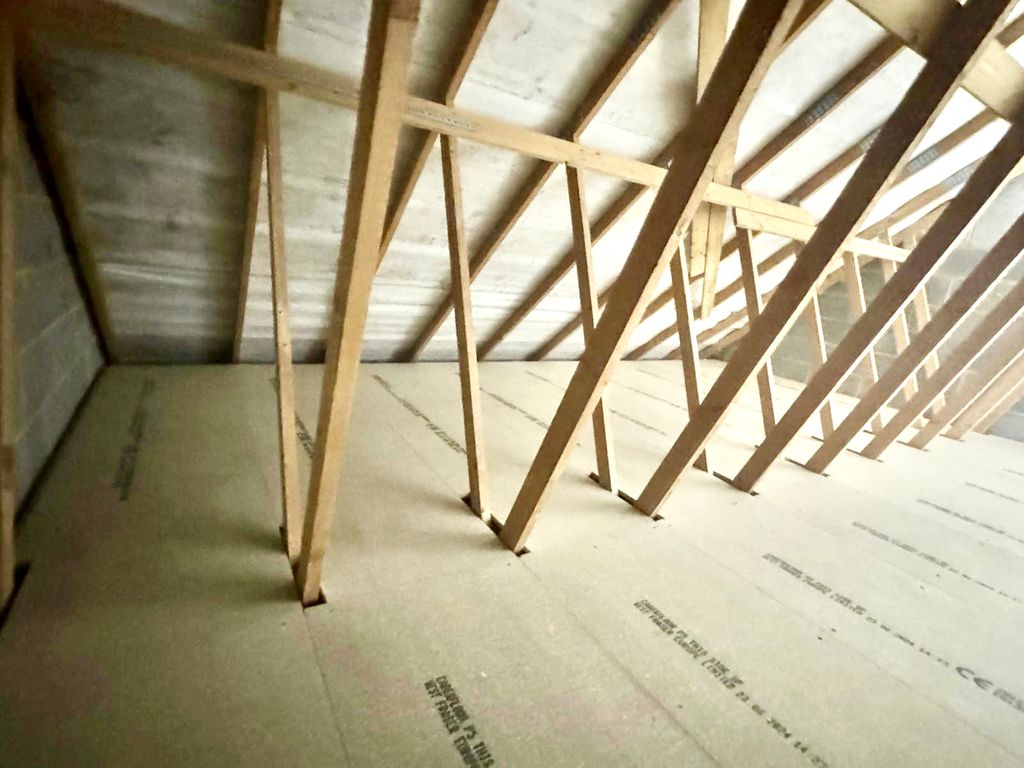 After: a clean, level P5 chipboard floor on raised loft legs, ready for storage