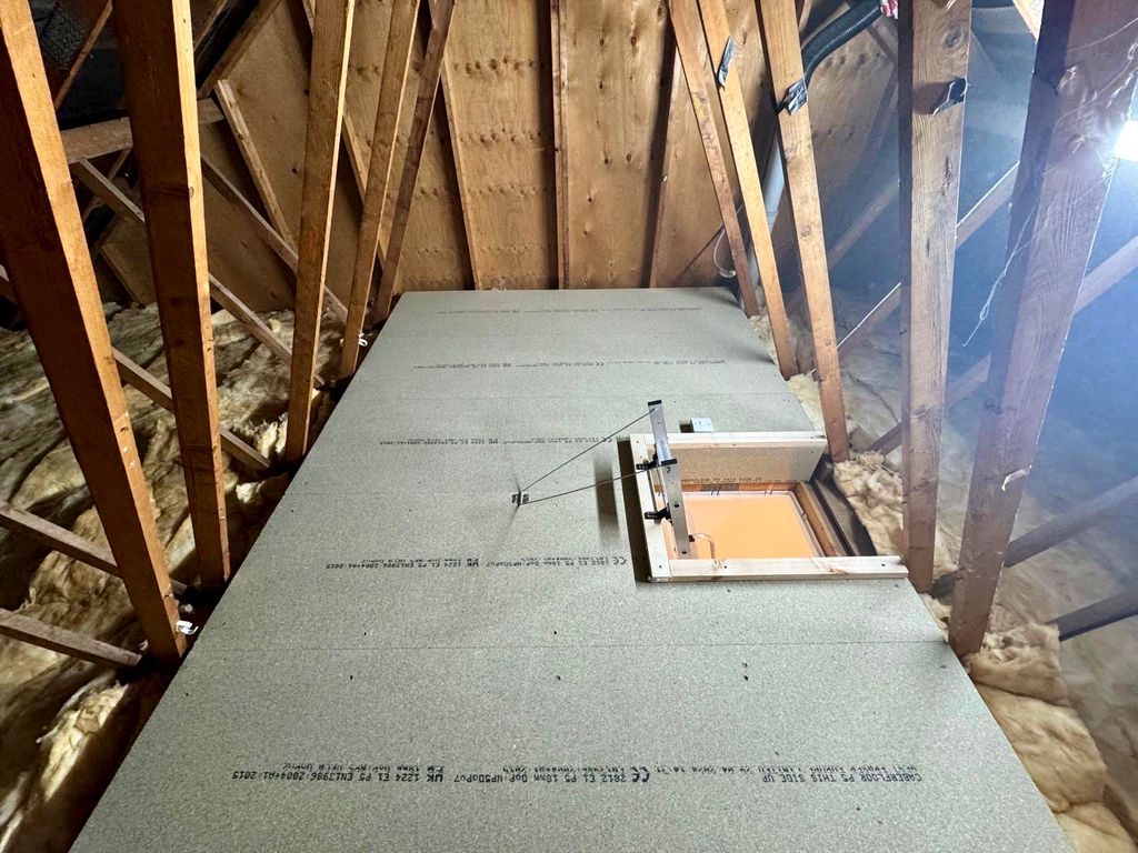 Raised loft boarding fitted between roof trusses