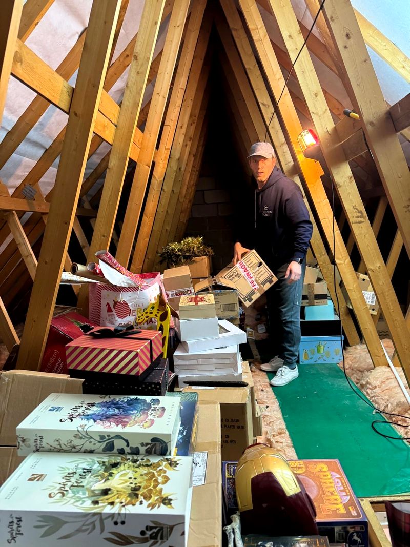 A homeowner organising storage boxes in a newly boarded loft